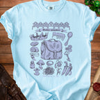 Light blue t-shirt with a "Goblin valuables" graphic featuring a satchel, broken crown, and various trinkets.