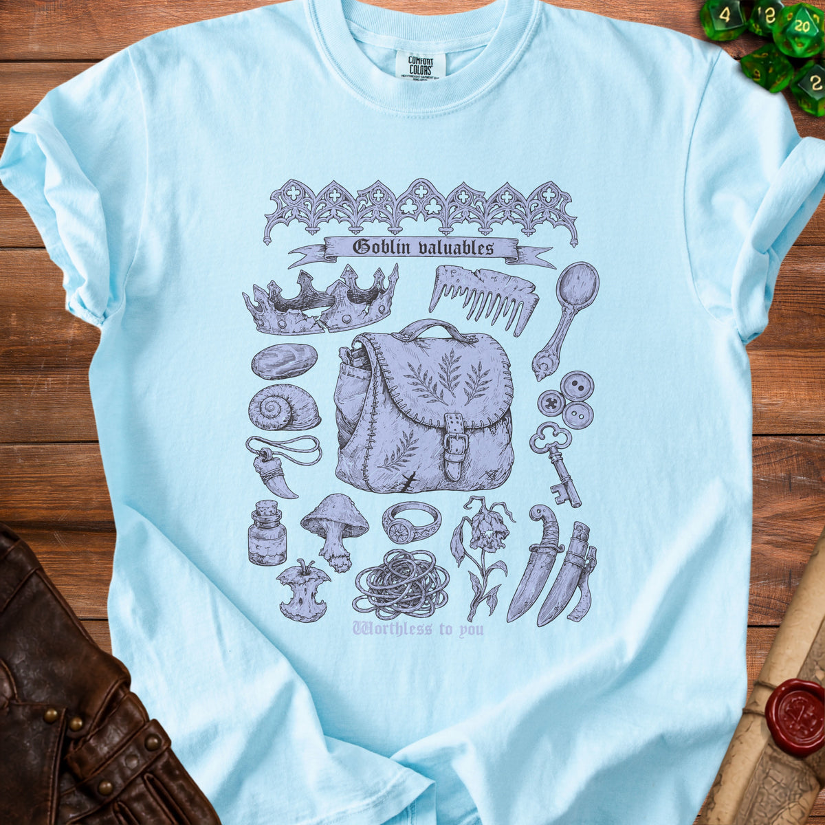 Light blue t-shirt with a "Goblin valuables" graphic featuring a satchel, broken crown, and various trinkets.