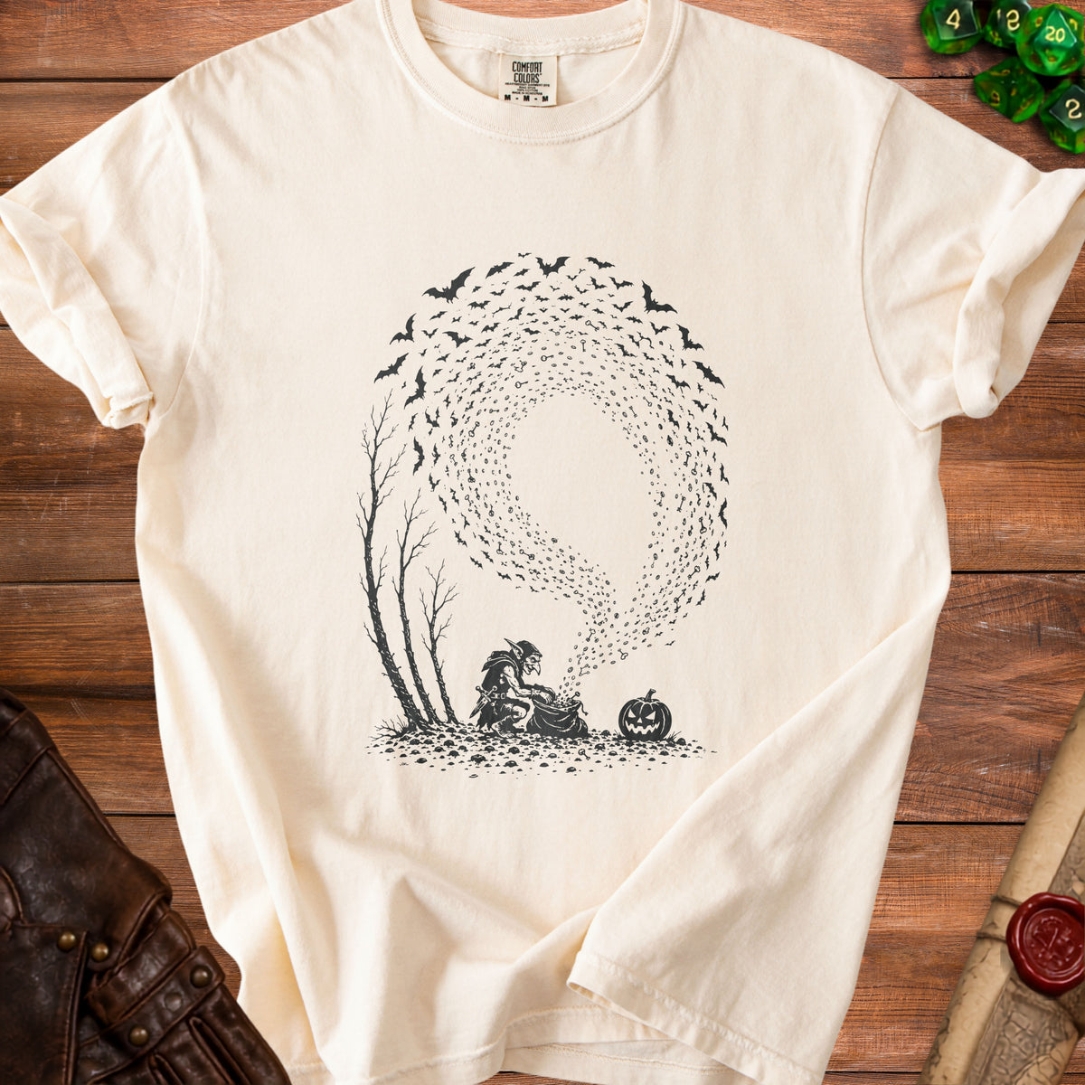 Goblin with bag of keys, pumpkin, and swarm of bats graphic on cream t-shirt.