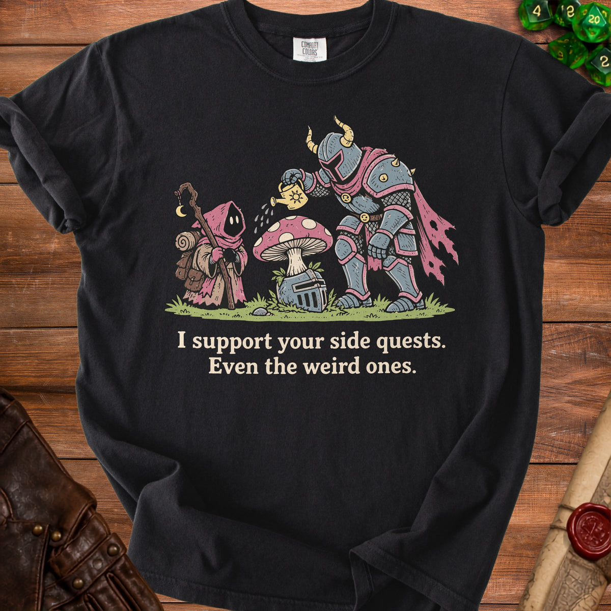 Black t-shirt featuring a knight watering a mushroom and a cloaked figure. Text reads: "I support your side quests. Even the weird ones."
