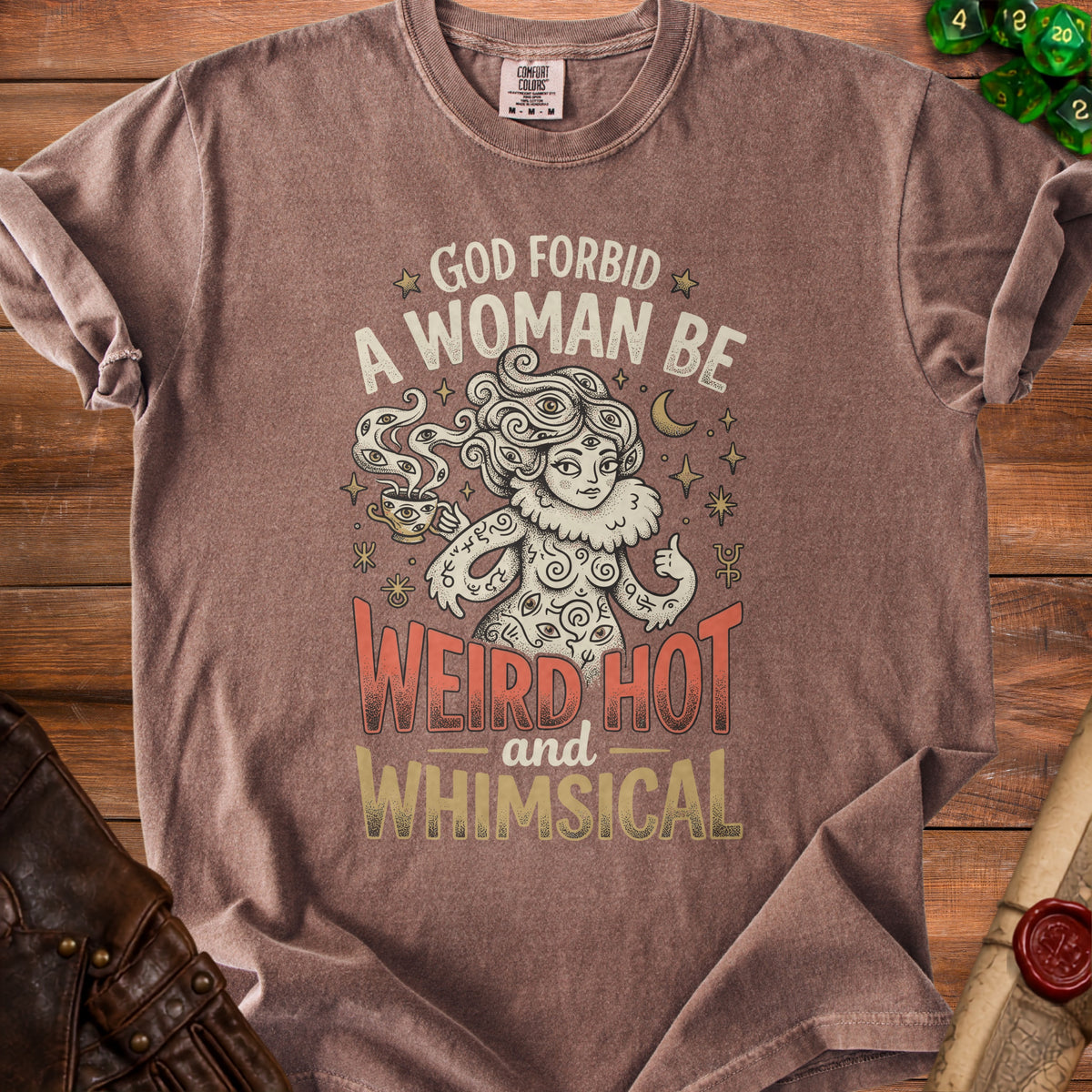 Brown t-shirt with "God forbid a woman be weird hot and whimsical" text and illustration.