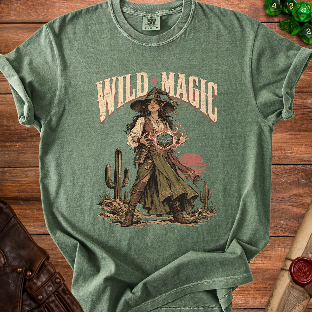Green t-shirt with "Wild Magic" text and an illustration of a witch holding a D20 die.