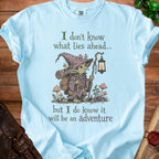 Light blue t-shirt with a goblin adventurer and text "I don't know what lies ahead... but I do know it will be an adventure."