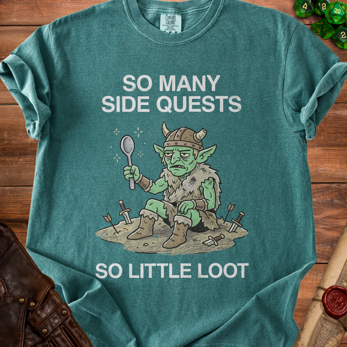 Teal t-shirt with illustration of a tired goblin holding a spoon and text "SO MANY SIDE QUESTS SO LITTLE LOOT".