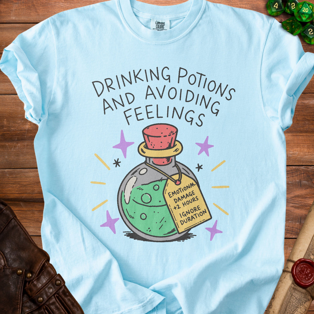 Light blue t-shirt with "DRINKING POTIONS AND AVOIDING FEELINGS" and a potion tag.