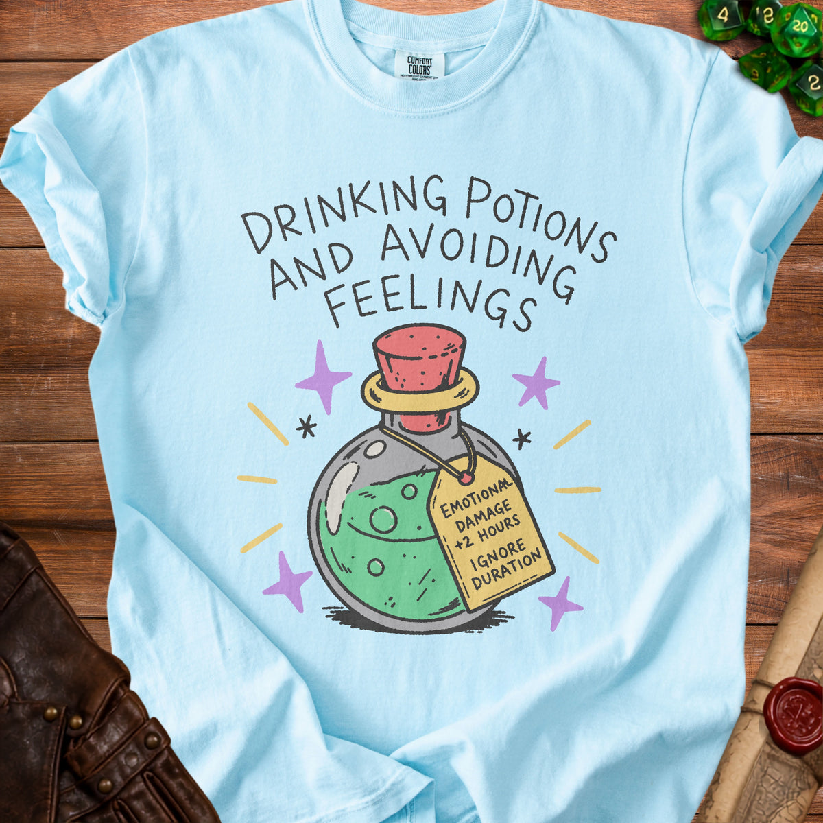 Light blue t-shirt with "DRINKING POTIONS AND AVOIDING FEELINGS" and a potion tag.