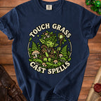Dark blue t-shirt with "Touch Grass Cast Spells" text and a forest sprite design.