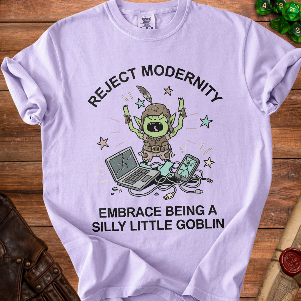 Lilac t-shirt with a goblin illustration and text reading "REJECT MODERNITY EMBRACE BEING A SILLY LITTLE GOBLIN."