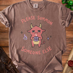 Brown t-shirt with a red demon holding a pentagram mug and text "PLEASE SUMMON SOMEONE ELSE".