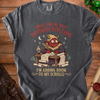 Dark gray t-shirt with a graphic of a red-faced demon writing "I'M ADDING DOOM TO MY SCROLLS".