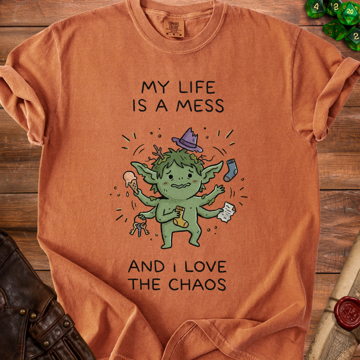 Orange t-shirt with cartoon goblin and text "MY LIFE IS A MESS AND I LOVE THE CHAOS".
