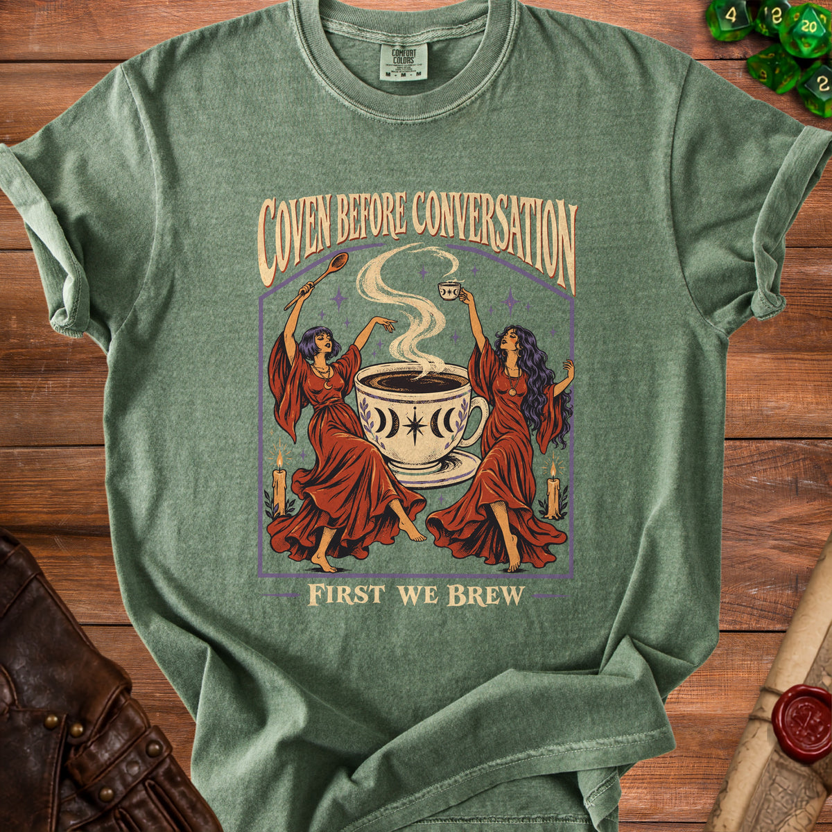 Green t-shirt with "Coven Before Conversation" and "First We Brew" text and graphic.