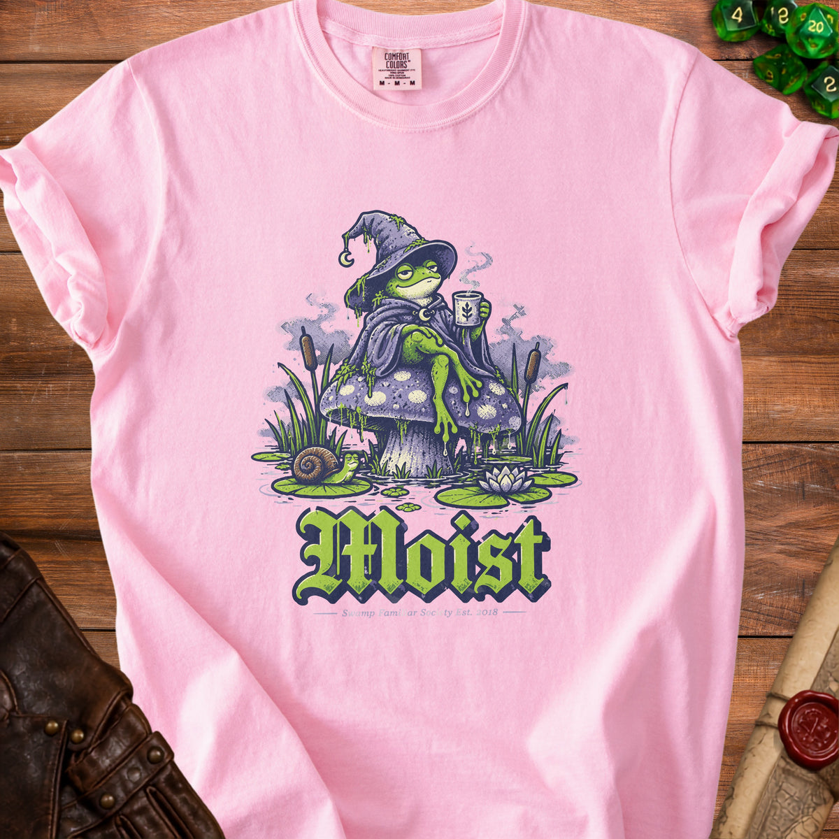 Pink t-shirt with a wizard frog holding coffee and the word "Moist".