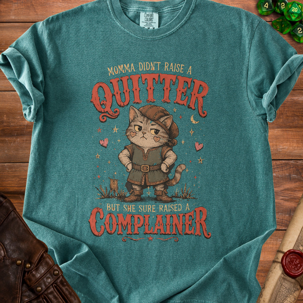 Teal t-shirt with cat character and text: "Momma didn't raise a quitter, but she sure raised a complainer."