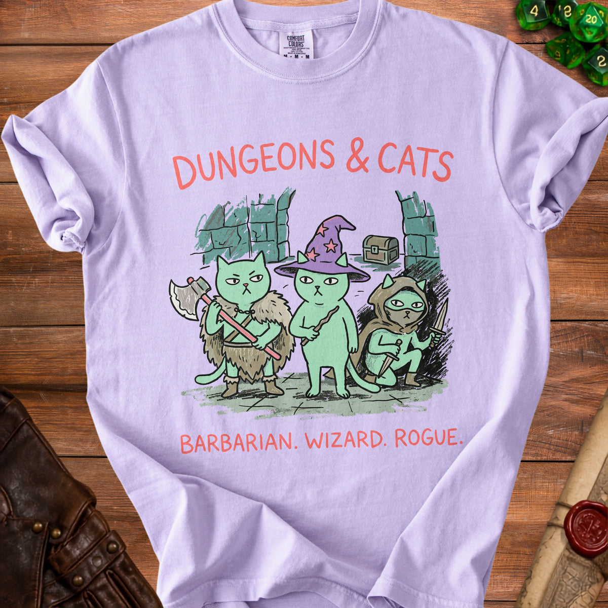 Light purple t-shirt with "DUNGEONS & CATS" and three cats as barbarian, wizard, and rogue.