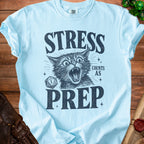 Light blue t-shirt with distressed print of a cat and text "STRESS COUNTS AS PREP".