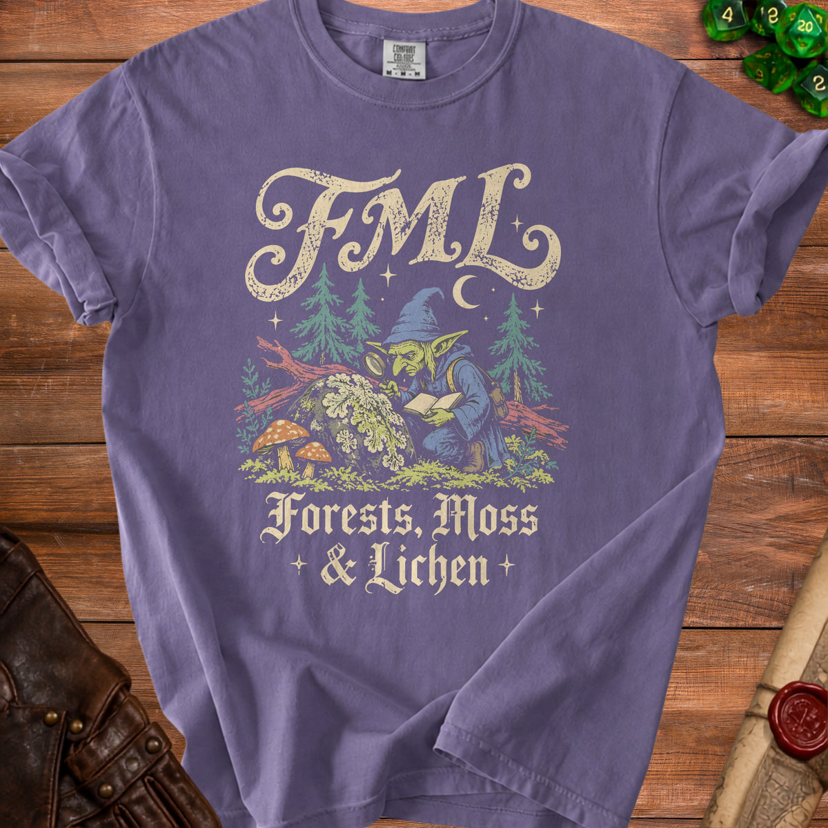 Purple t-shirt with FML and a goblin reading among forests, moss, and lichen.