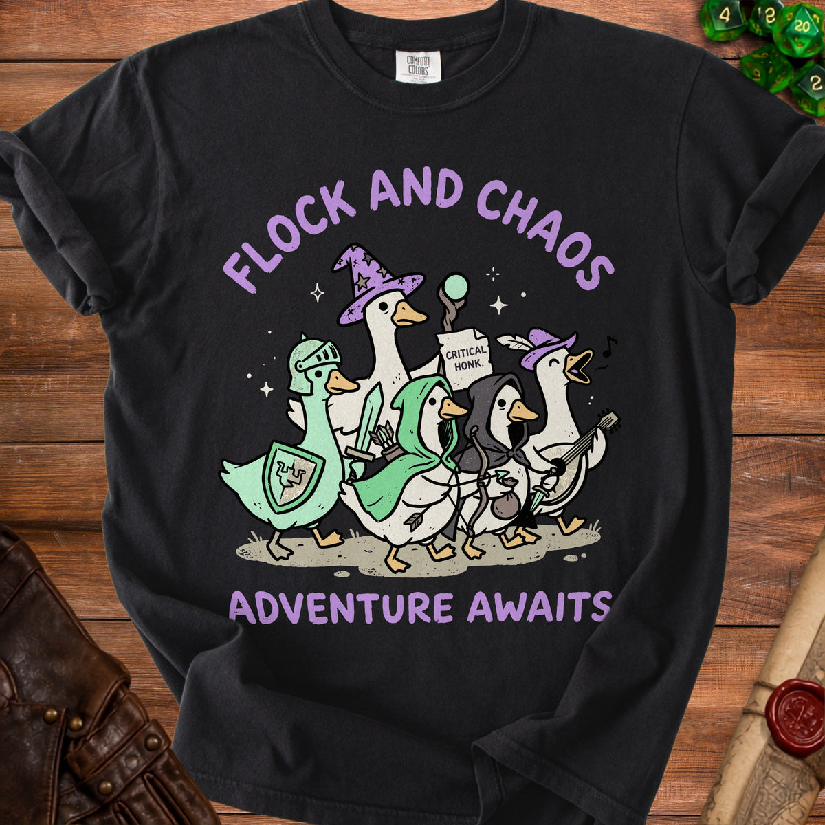 Black t-shirt with a graphic of ducks dressed as fantasy adventurers, saying "Flock and Chaos Adventure Awaits".