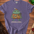 Purple t-shirt with a cartoon frog playing a lute and the text "CROAK & ROLL".