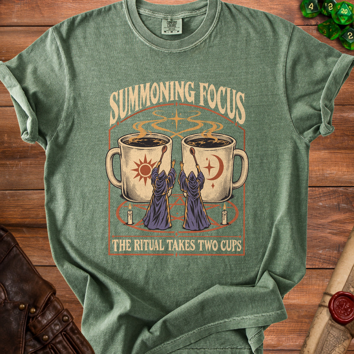 Green t-shirt with Summoning Focus text and wizards with cups graphic.