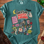 Green t-shirt with "Quest Log: Mostly Errands" graphic featuring a witch, Grogu, and various fantasy elements.