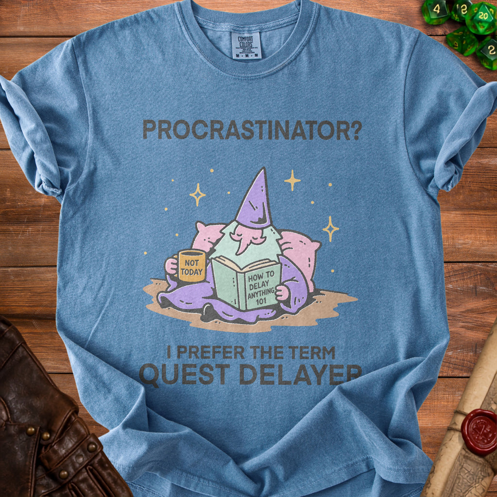 Blue t-shirt with "PROCASTINATOR? I PREFER THE TERM QUEST DELAYER" text and wizard graphic.