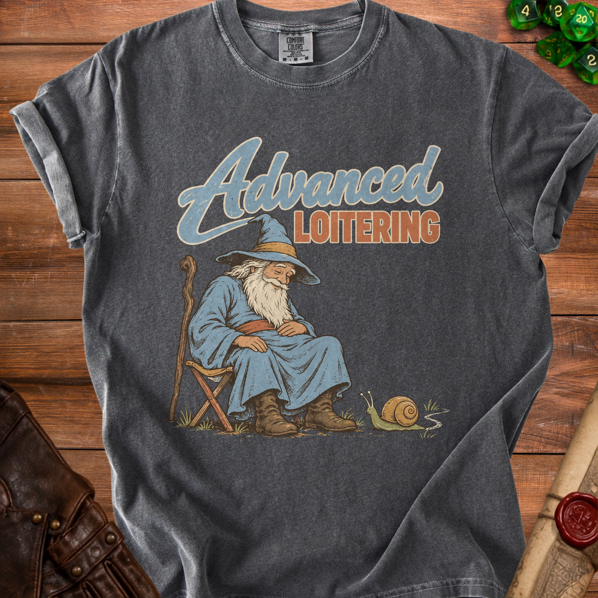 Dark gray t-shirt with a vintage graphic of a sleeping wizard sitting in a chair, accompanied by text reading Advanced Loitering.