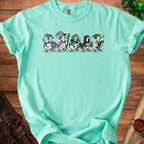 Teal t-shirt with cartoon ducks dressed as fantasy adventurers and playing instruments.