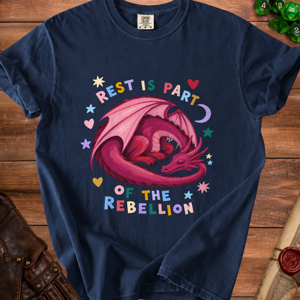 Dark blue t-shirt with a pink dragon and the text "REST IS PART OF THE REBELLION".