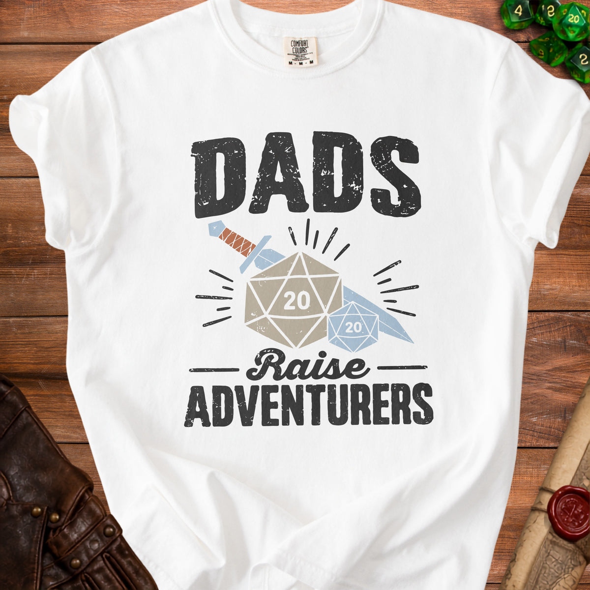 White t-shirt with "DADS Raise ADVENTURERS" graphic and dice.