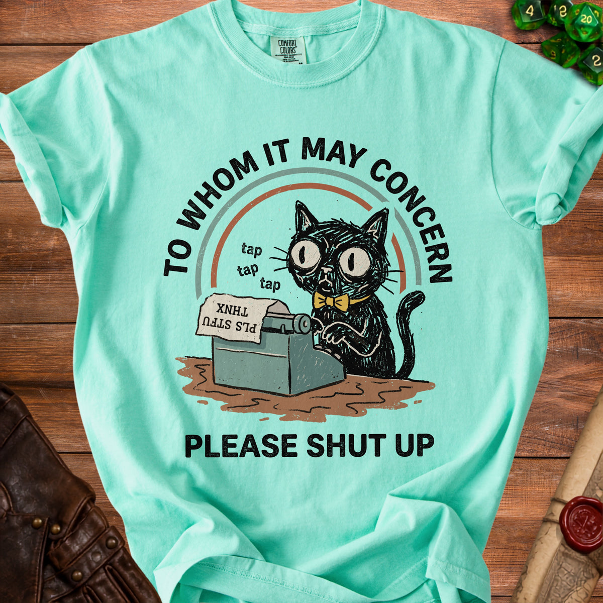Mint green t-shirt with a graphic of a cat typing on a typewriter.
