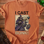 Orange t-shirt with wizard hitting skeleton with club and text "I CAST BONK!"