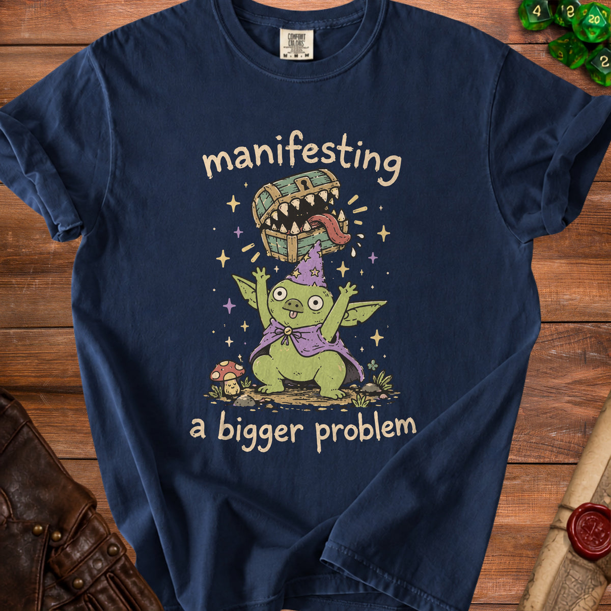 Dark blue t-shirt with text "manifesting a bigger problem" and goblin creature.