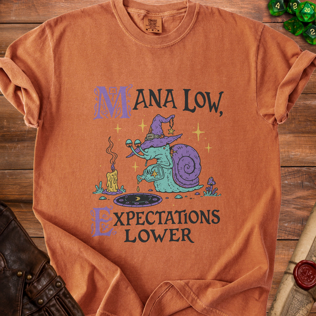 Orange t-shirt with "Mana Low, Expectations Lower" text and a snail wizard graphic.