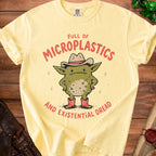 Yellow t-shirt with graphic of a goblin in a cowboy hat and boots, reading "Full of Microplastics and Existential Dread".