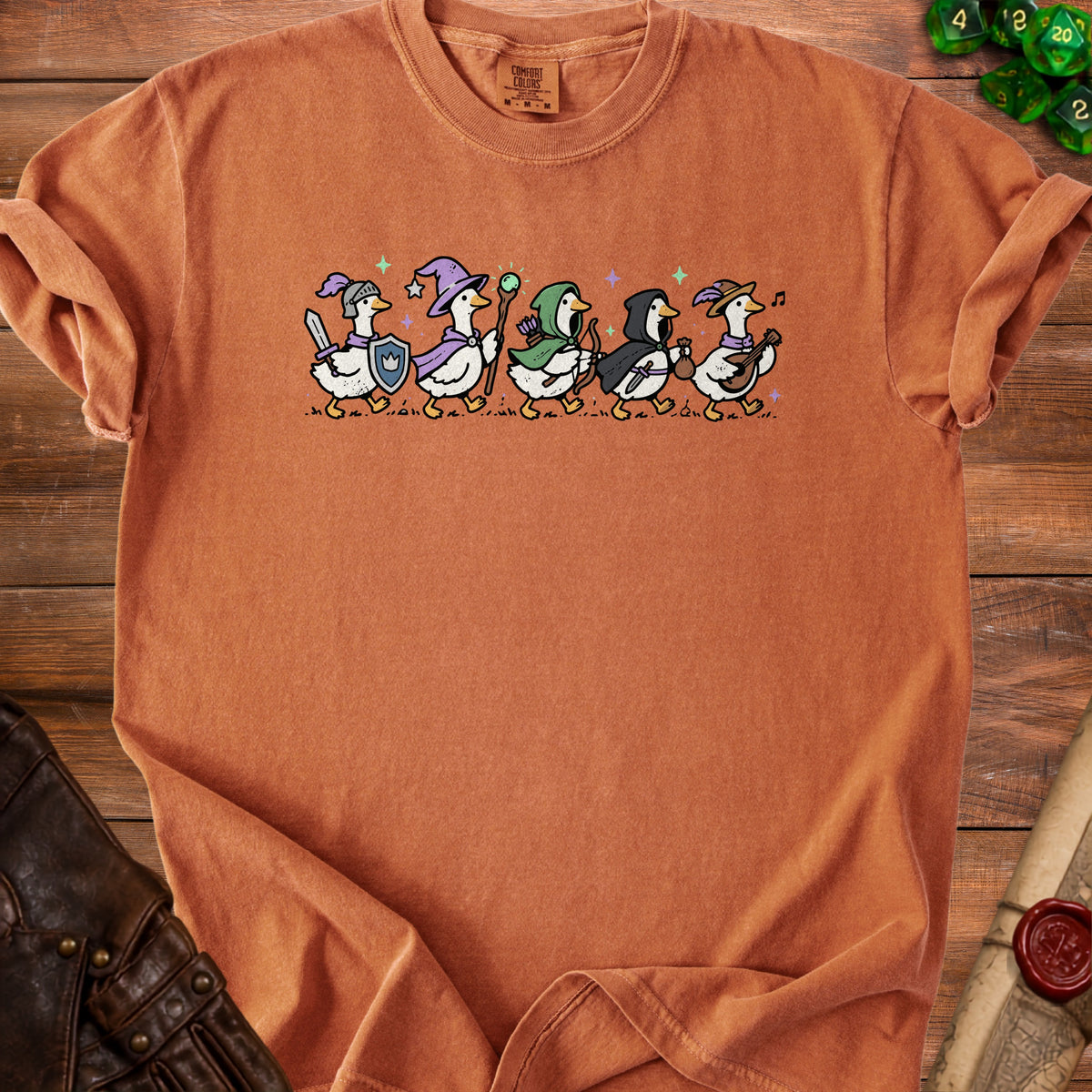 Orange t-shirt featuring a line of cartoon geese dressed as fantasy characters.