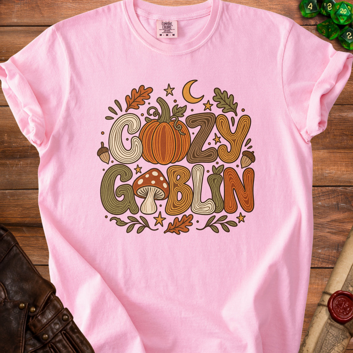 Pink t-shirt with "Cozy Goblin" text and fall graphics.