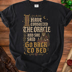 Black t-shirt with text "I HAVE CONSULTED THE ORACLE AND SHE SAID GO BACK TO BED".