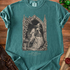 Green t-shirt with a gothic art print of a tired witch reading and a rat.