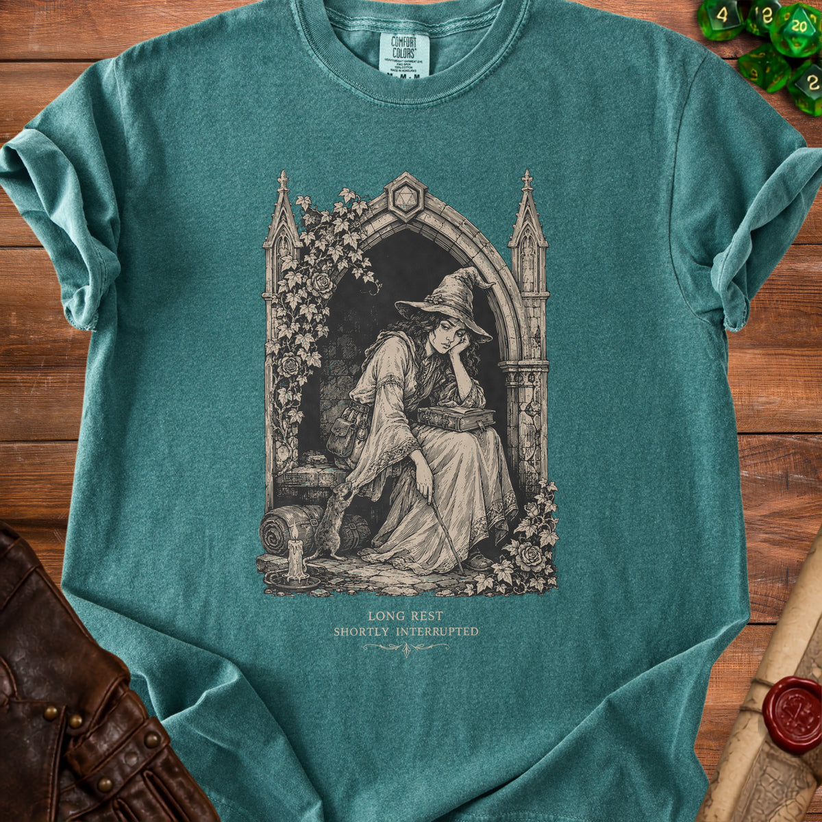 Green t-shirt with a gothic art print of a tired witch reading and a rat.