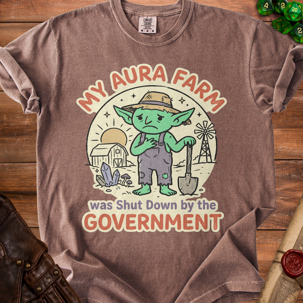 T-shirt graphic: Sad goblin farmer holding a shovel with text "My Aura Farm was Shut Down by the Government".