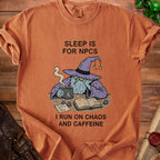 T-shirt with wizard graphic and text "Sleep is for NPCs. I run on chaos and caffeine."