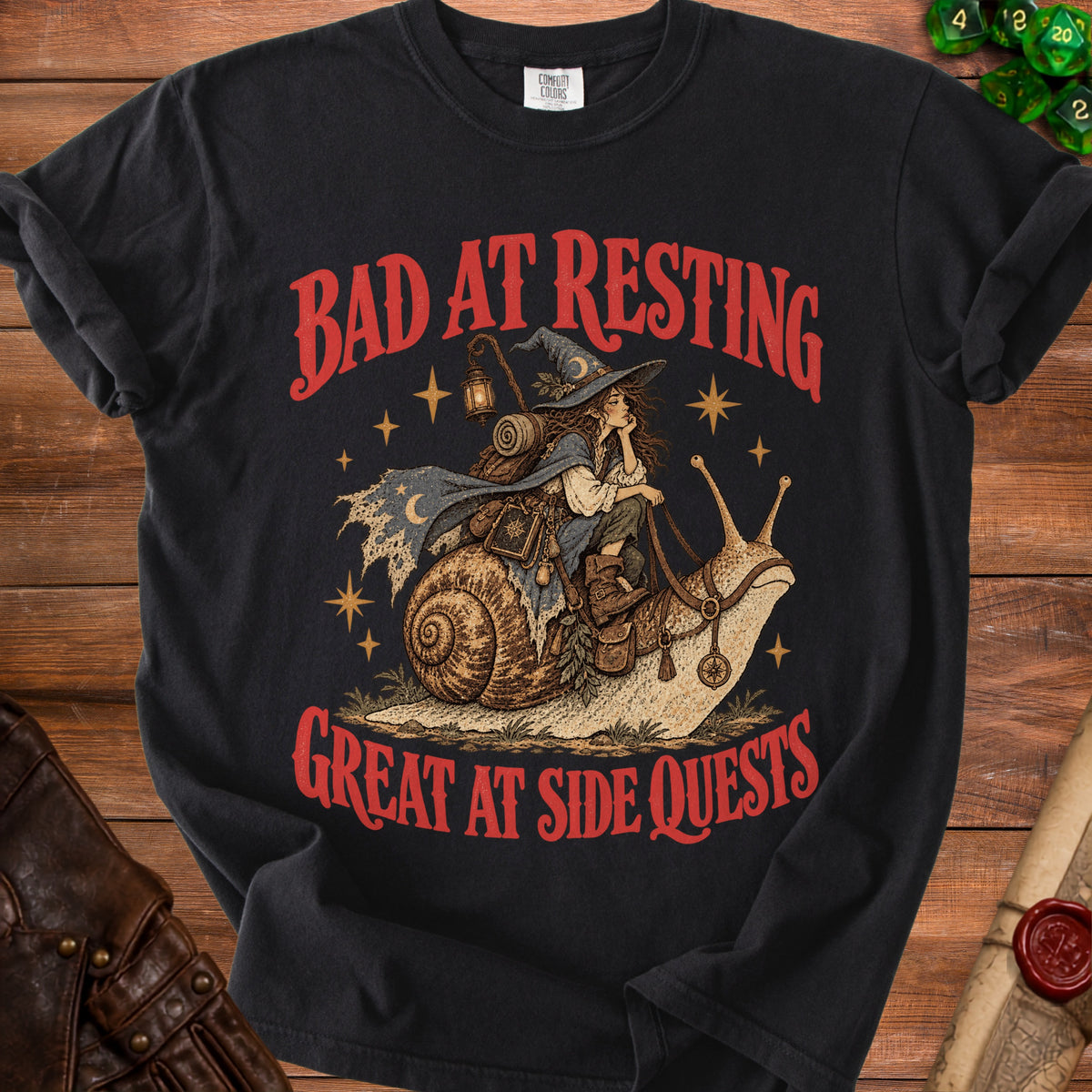 Black t-shirt with red text "BAD AT RESTING" and a drawing of a witch riding a snail.