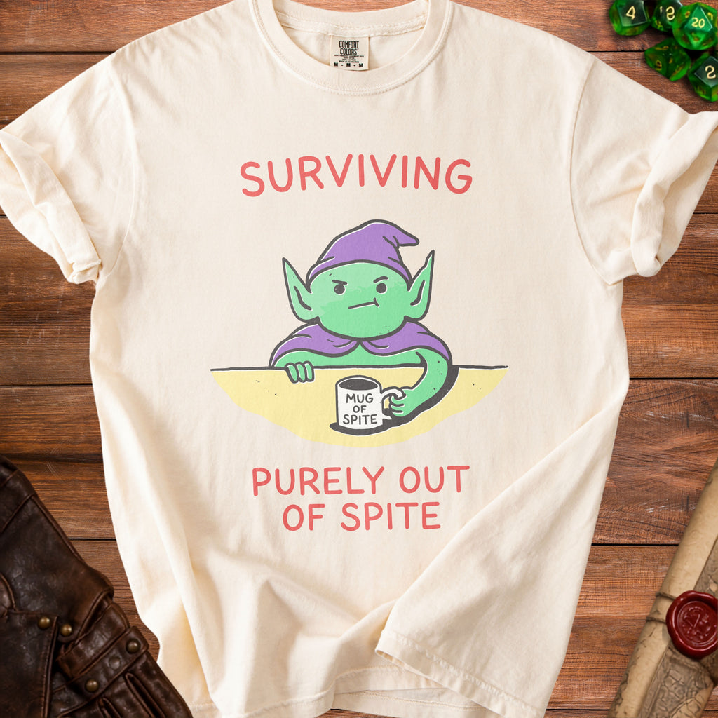 Cream t-shirt with green goblin graphic and text "SURVIVING PURELY OUT OF SPITE".