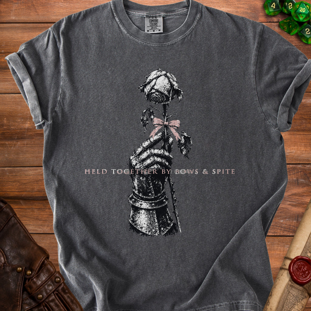 Dark grey t-shirt with a knight's gauntlet holding a rose, text "HELD TOGETHER BY BOWS & SPITE".