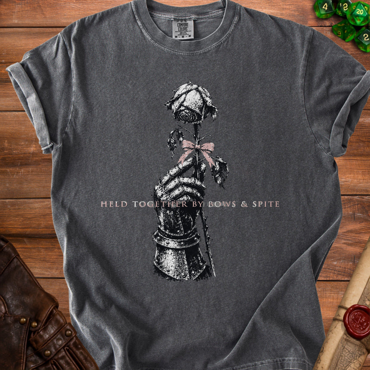 Dark grey t-shirt with a knight's gauntlet holding a rose, text "HELD TOGETHER BY BOWS & SPITE".