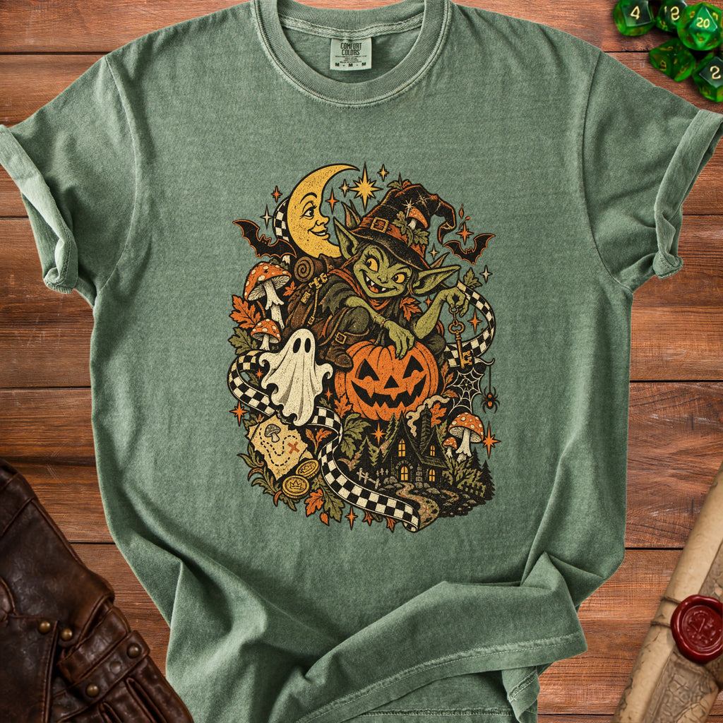 Green t-shirt featuring a goblin, moon, pumpkin, and spooky Halloween scene graphic.