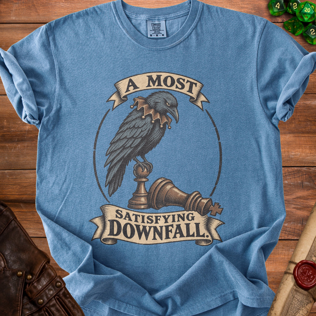 Blue t-shirt featuring a crow wearing a jester collar perched on a fallen chess piece.