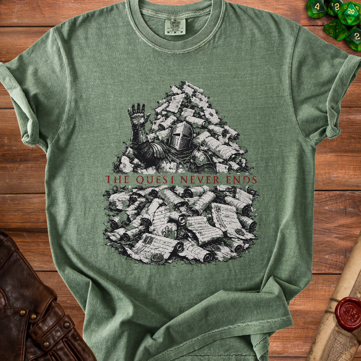 Green t-shirt with knight drowning in scrolls; text reads "The Quest Never Ends."