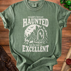 Green t-shirt with "Tonight's forecast HAUNTED but the loot is EXCELLENT" graphic.